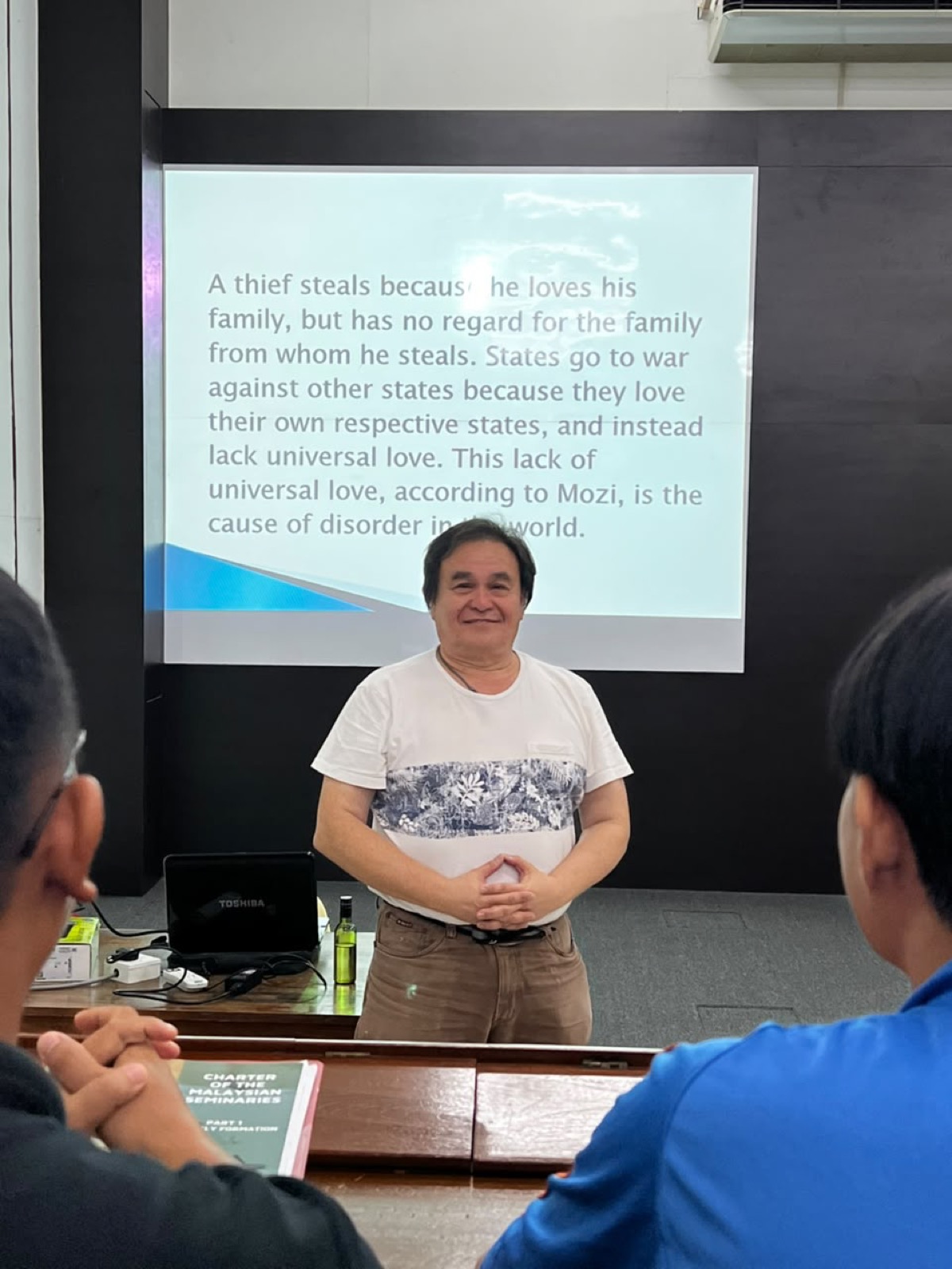 A first year philosophy session beside a projected reading on Mozi