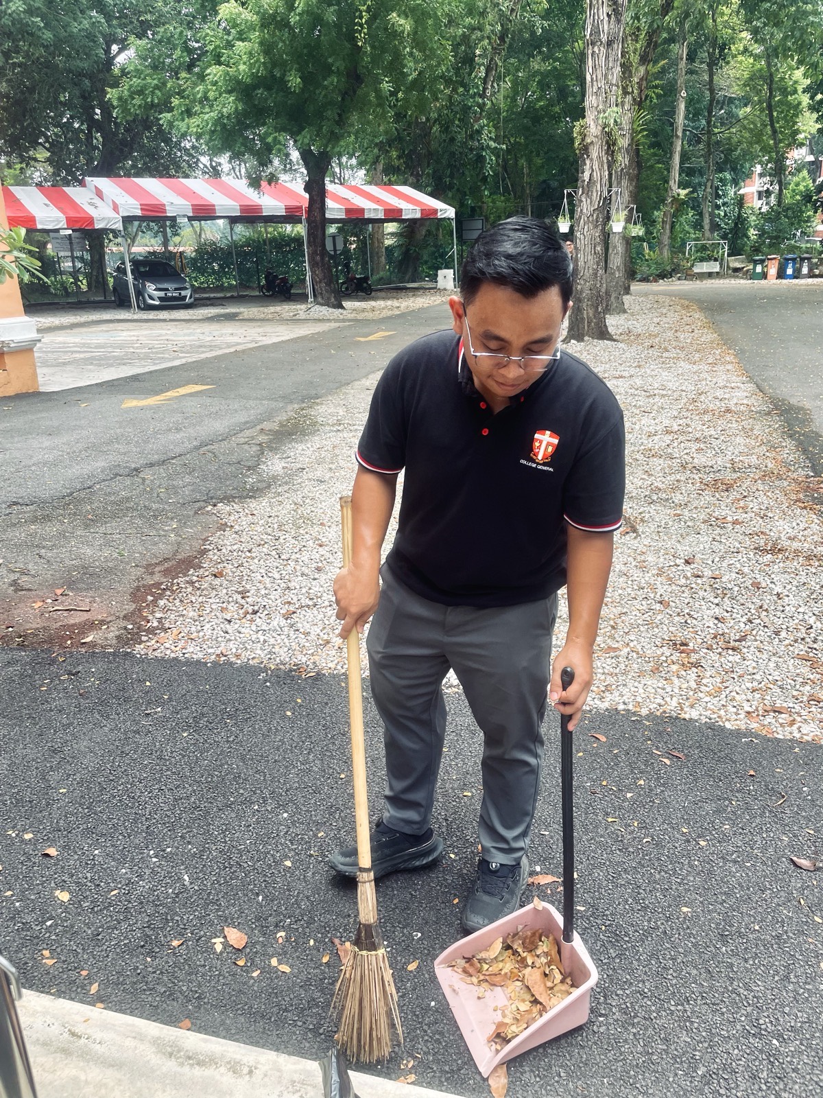 A seminarian sweeping the grounds as part of a service day