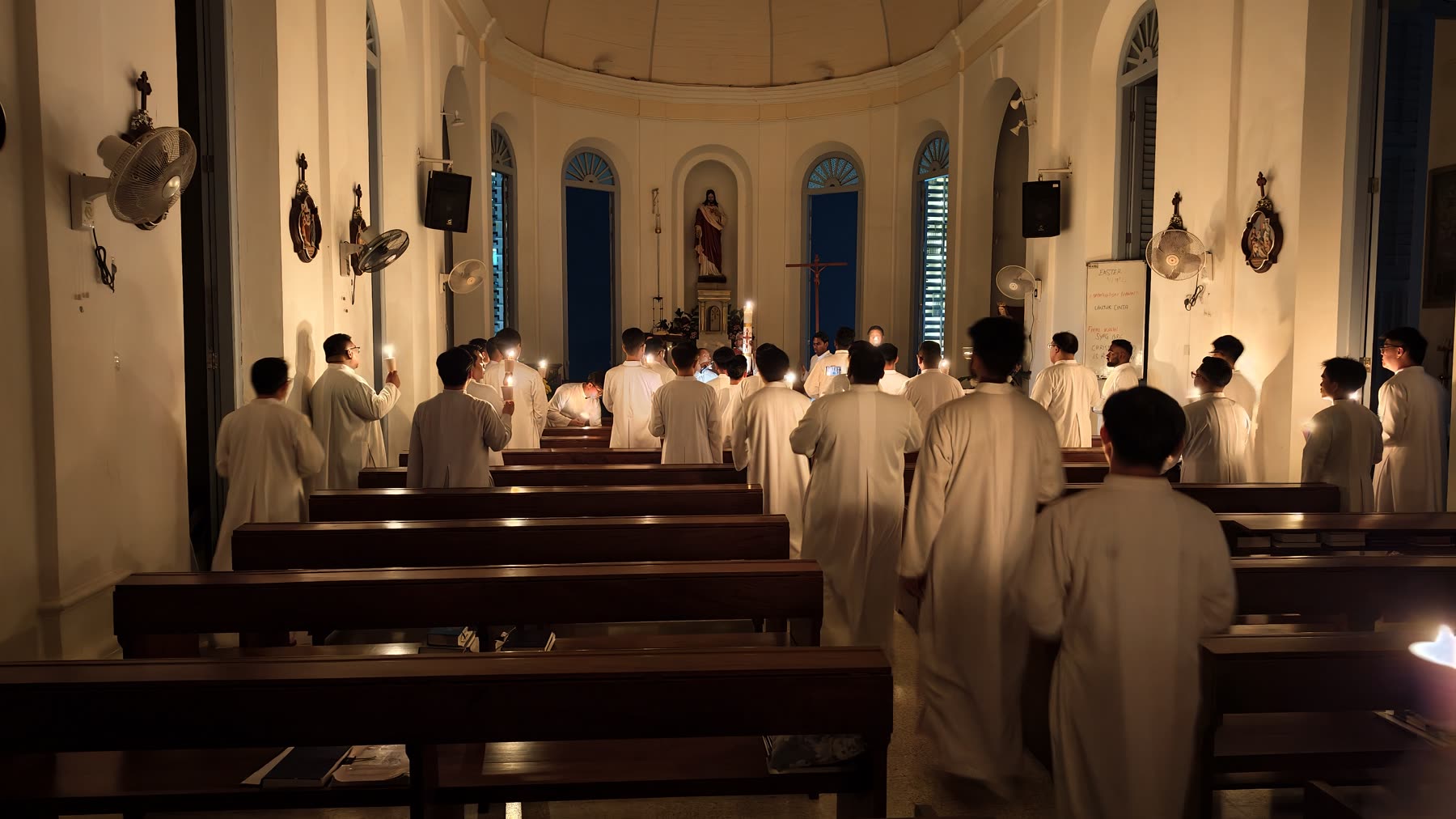 A candlelit procession moving through the chapel